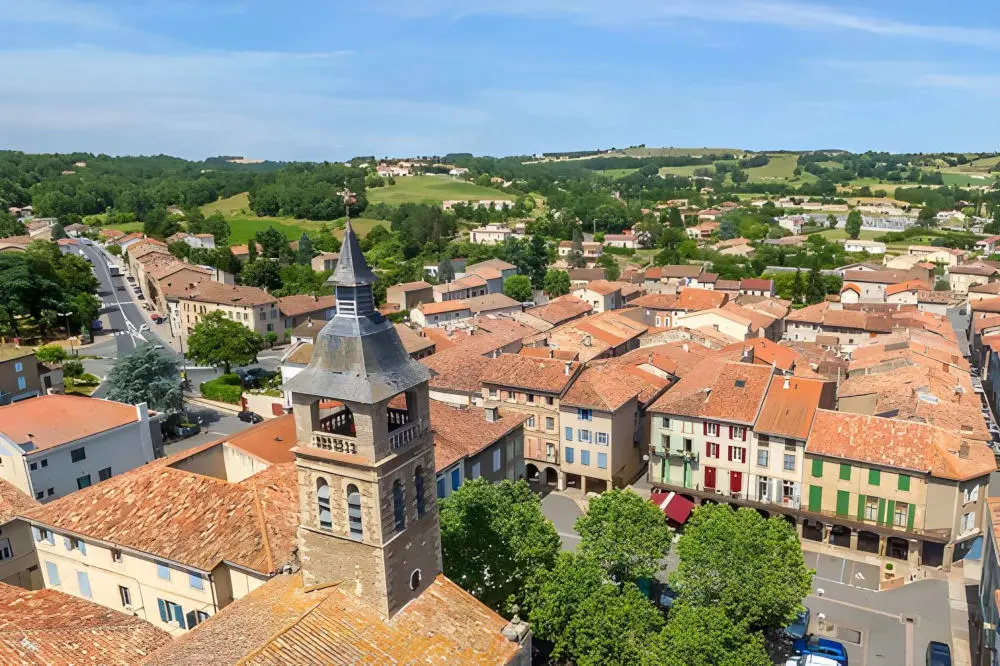 Vue aérienne de Réalmont, ses toits de tuiles et le clocher de l’église